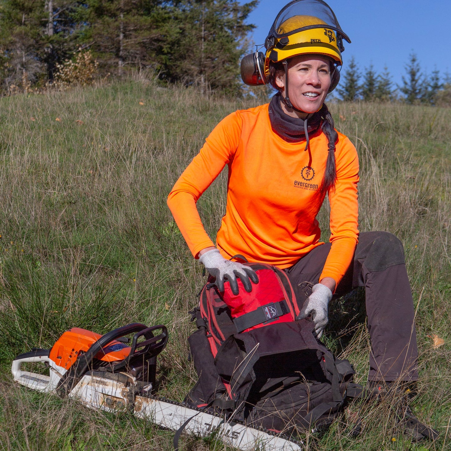 Trail builder from Evergreen Mountain Bike Alliance placing the Sawyer Backcountry Trauma kit inside her pack