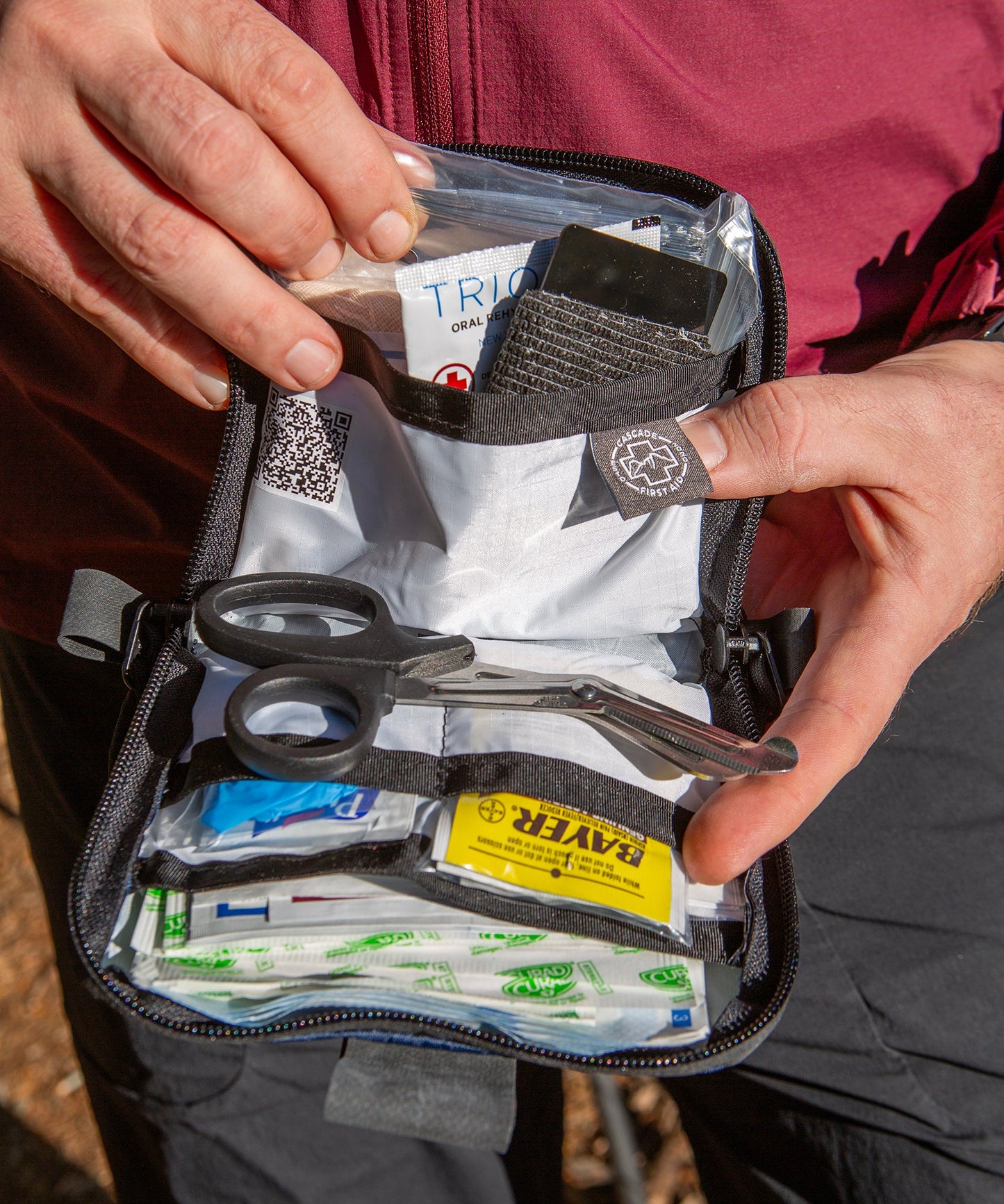 Mountain biker showing the contents inside the Galby Mountain Biking first aid kit from Cascade First Aid