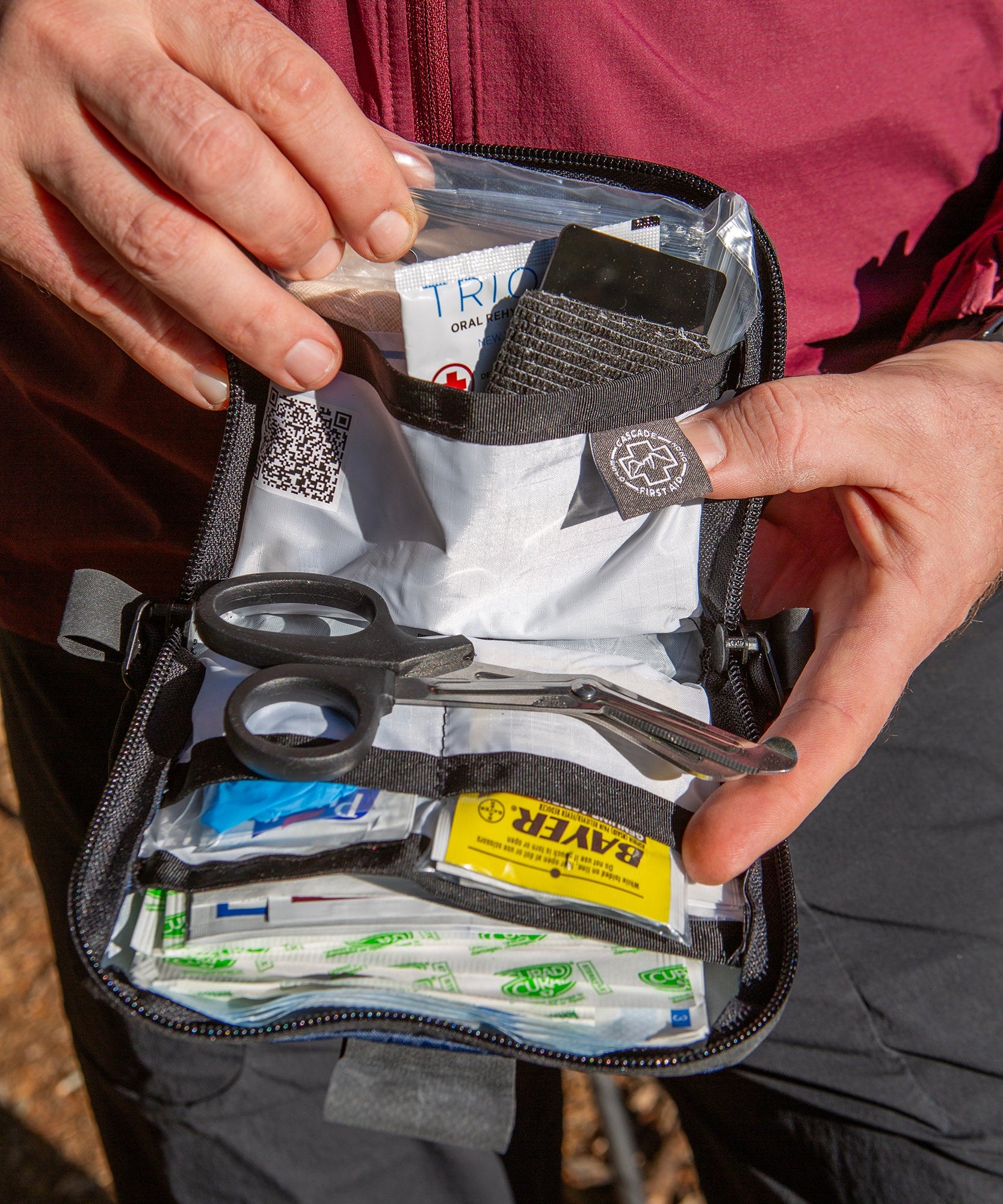 Mountain biker showing the contents inside the Galby Mountain Biking first aid kit from Cascade First Aid