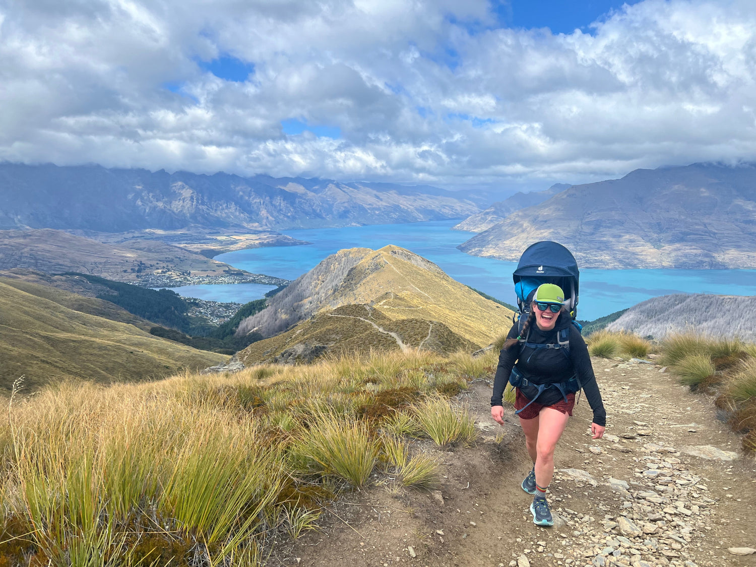 Mom (and owner of Cascade First Aid) hiking up mountain with toddler asleep in backpack carrier